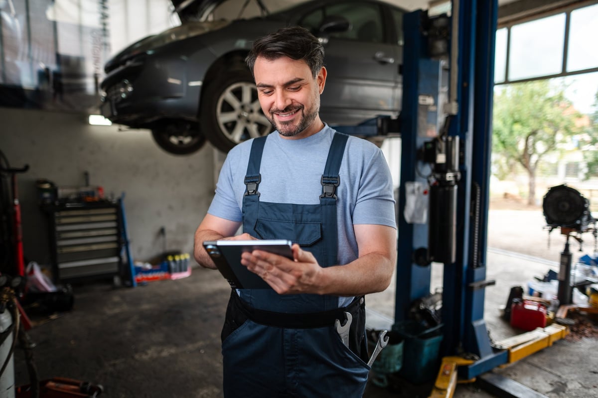 Mechanic using digital tablet in auto repair shop